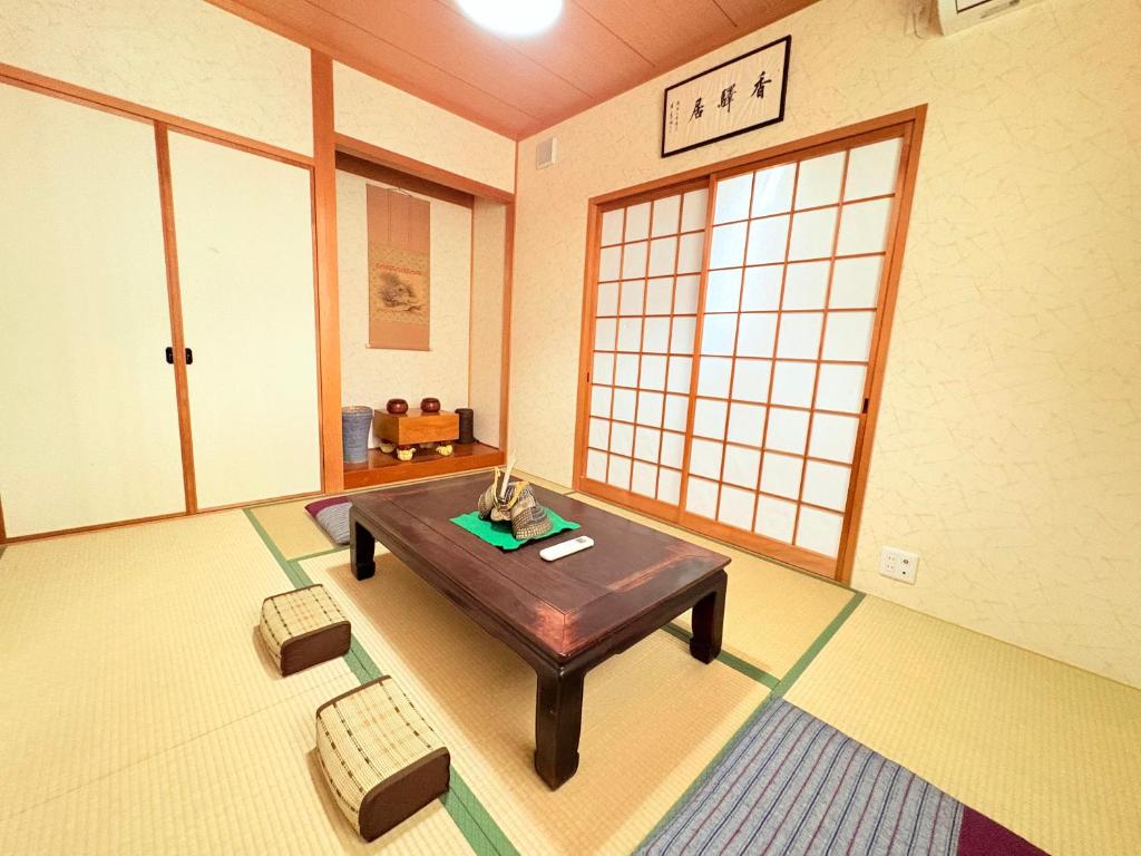 京都夏様香驛 Spacious 4 Bedroom Kyoto House with 2 Bathrooms,2 Toilets ,Sleeps up to 8的客厅配有桌子和两把椅子