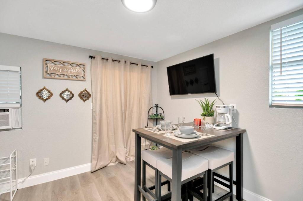 a room with a table with a tv on a wall at Newly Updated Modern 1-Bedroom Private Guesthouse in Clearwater