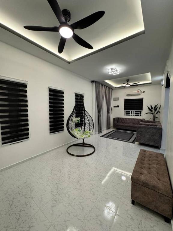 a living room with a ceiling fan and a chair at Azlynie Homestay in Kangar