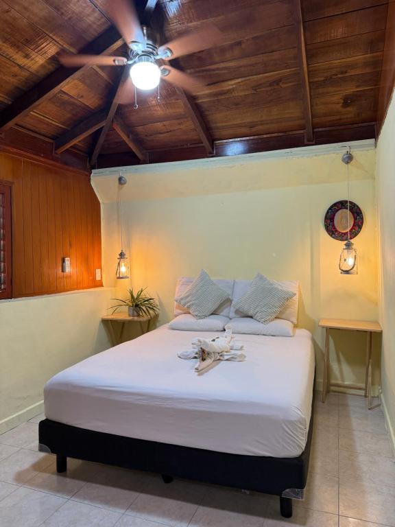 a bedroom with a large white bed with wooden ceilings at Maïa Bacalar in Bacalar