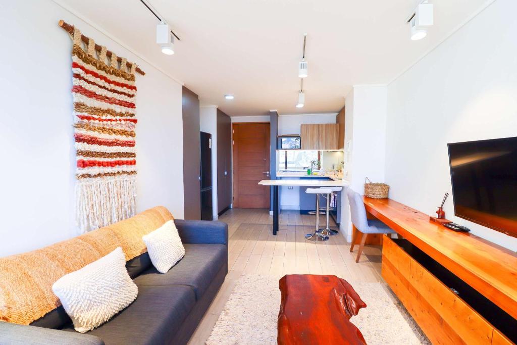 a living room with a couch and a flat screen tv at HOM I Depto con parking incluido 1D1B in Puerto Varas