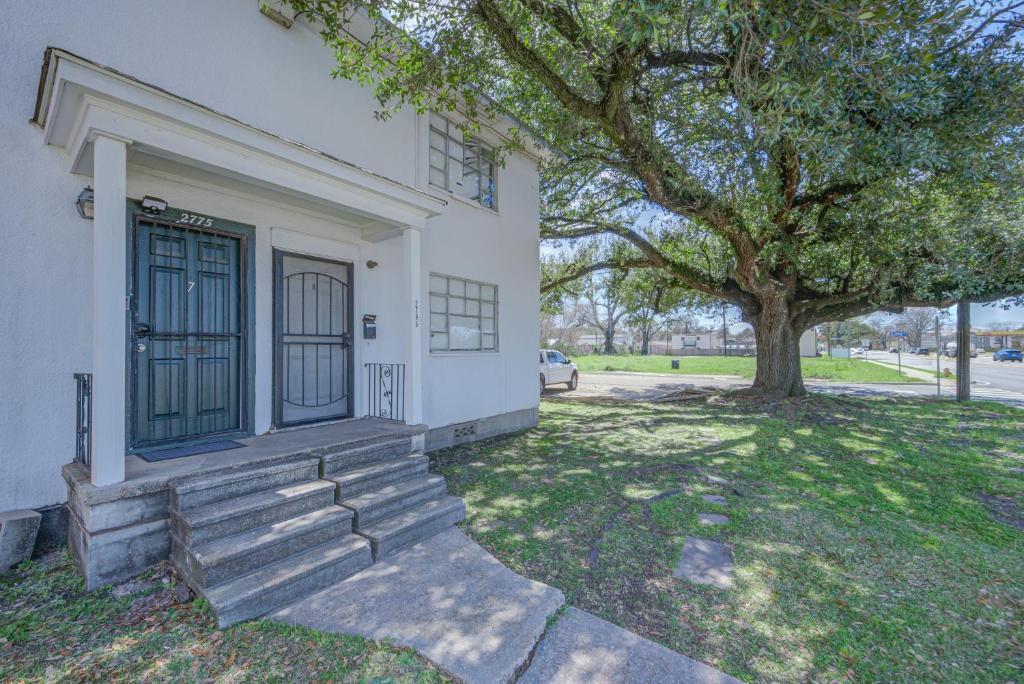 ein weißes Haus mit einem Baum im Hof in der Unterkunft 20 Minute Walk to Tiger Stadium - Near Downtown in Baton Rouge