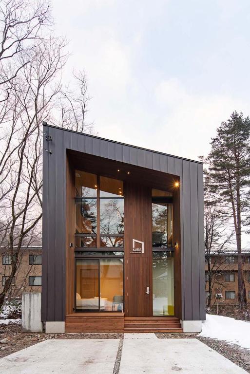 a small black building with a large glass door at Kairos by the Mountain in Hakuba