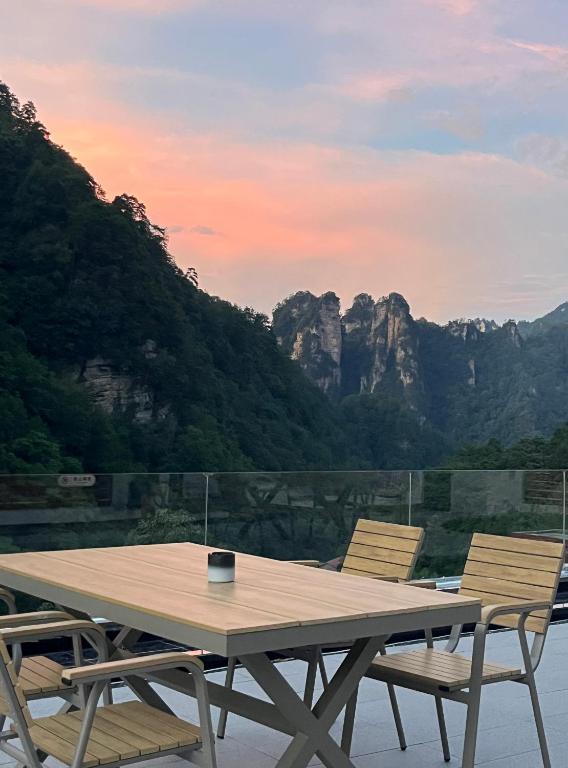 a picnic table with two chairs and a view of mountains at Nature Eco Designer Hotel--Avatar mountain view,Bubble Pool,Free shuttle to south gate of Park Entrance,Local trip plan & Tourism Service,Full Renovation for 10 months in Zhangjiajie