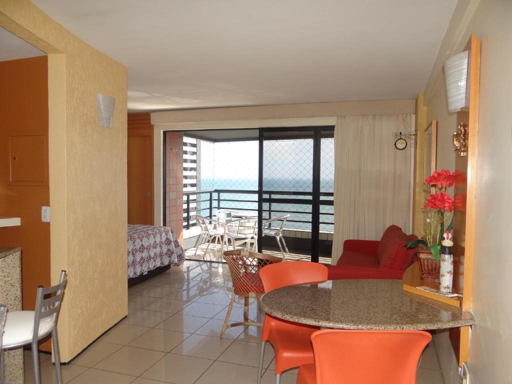 uma sala de estar com uma mesa e cadeiras e uma varanda em Apartamento Em Andar Alto com Vista Mar Meireles em Fortaleza