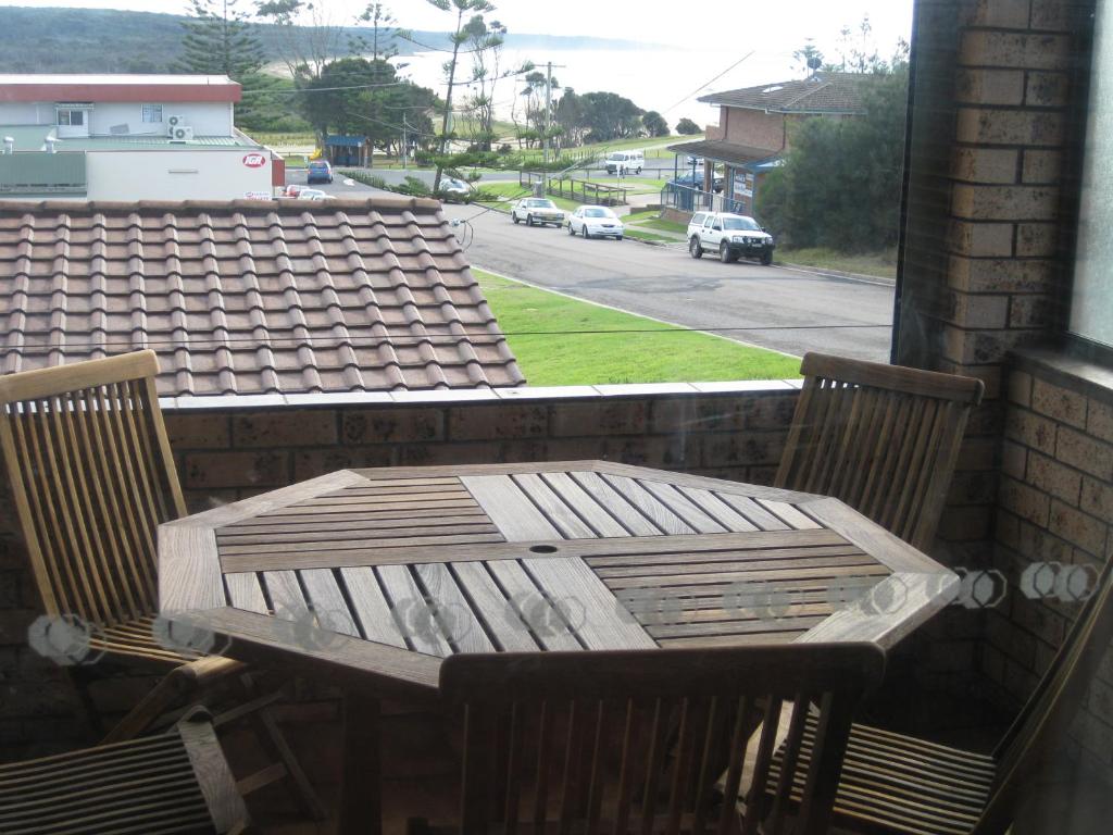 - Balcón con mesa de madera y 2 sillas en Dalmeny Shores, en Dalmeny