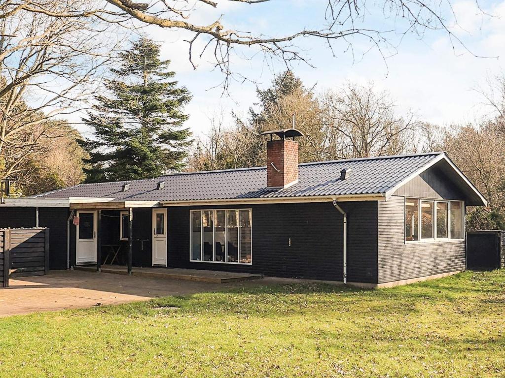 a house with a brick chimney on top of it at 7 person holiday home in Spøttrup in Spottrup