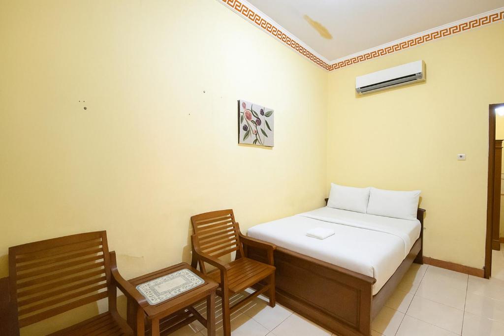 Postel nebo postele na pokoji v ubytování Wisma Kartini Syariah near Alun Alun Sidoarjo RedPartner