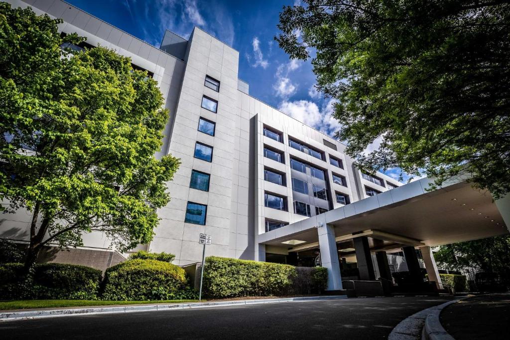 Un edificio blanco con una calle enfrente. en Crowne Plaza Canberra by IHG, en Canberra