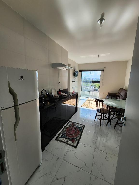 a kitchen with a white refrigerator and a table at apartamento in Tijucas