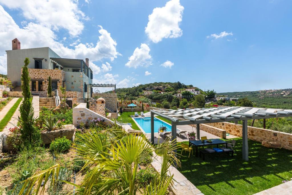 a villa with a swimming pool and a house at ERONDAS Cretan Country Villas in Achlades