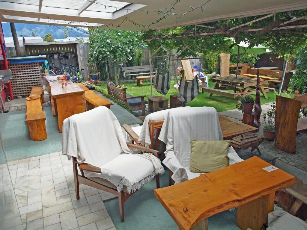 d'une terrasse avec une table, des chaises, une table et des bancs. dans l'établissement Annies Nirvana Lodge Backpackers, à Takaka