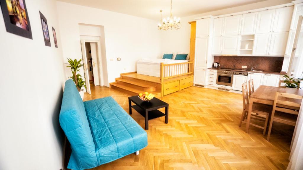 uma sala de estar com um sofá azul e uma mesa em Apartment by the Old Town Square em Praga