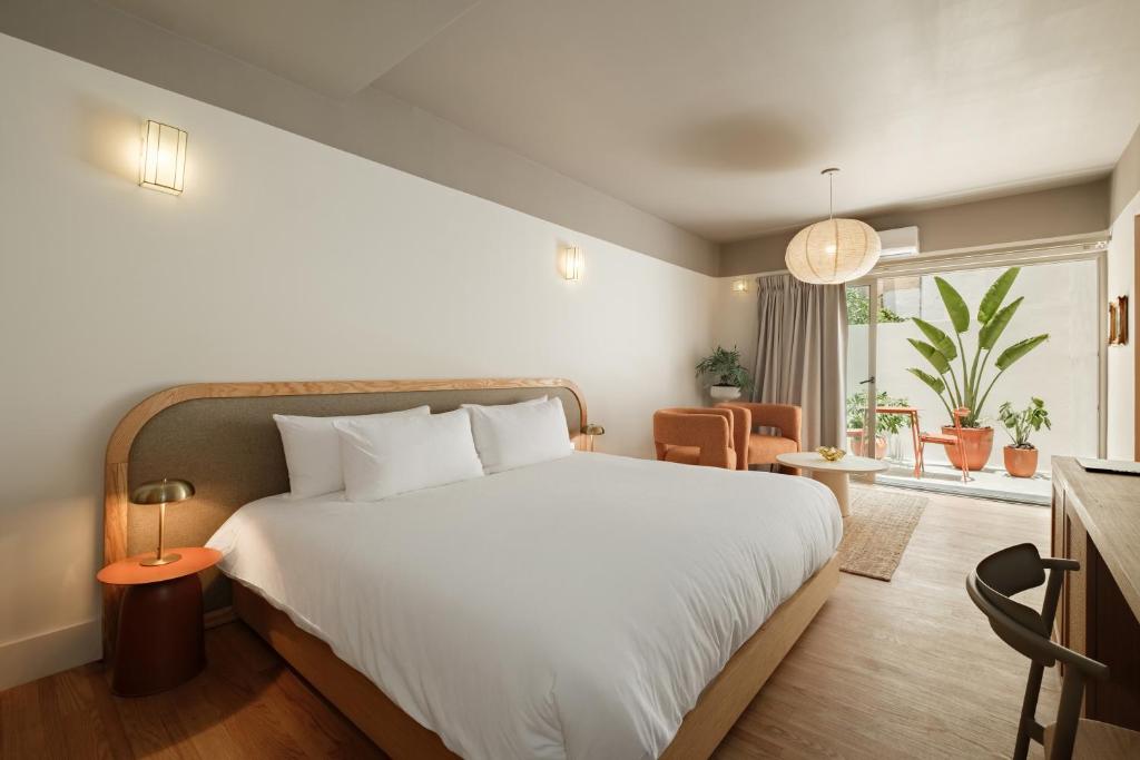 a bedroom with a large white bed and a window at Cholula Condesa Hotel by Lumina in Mexico City