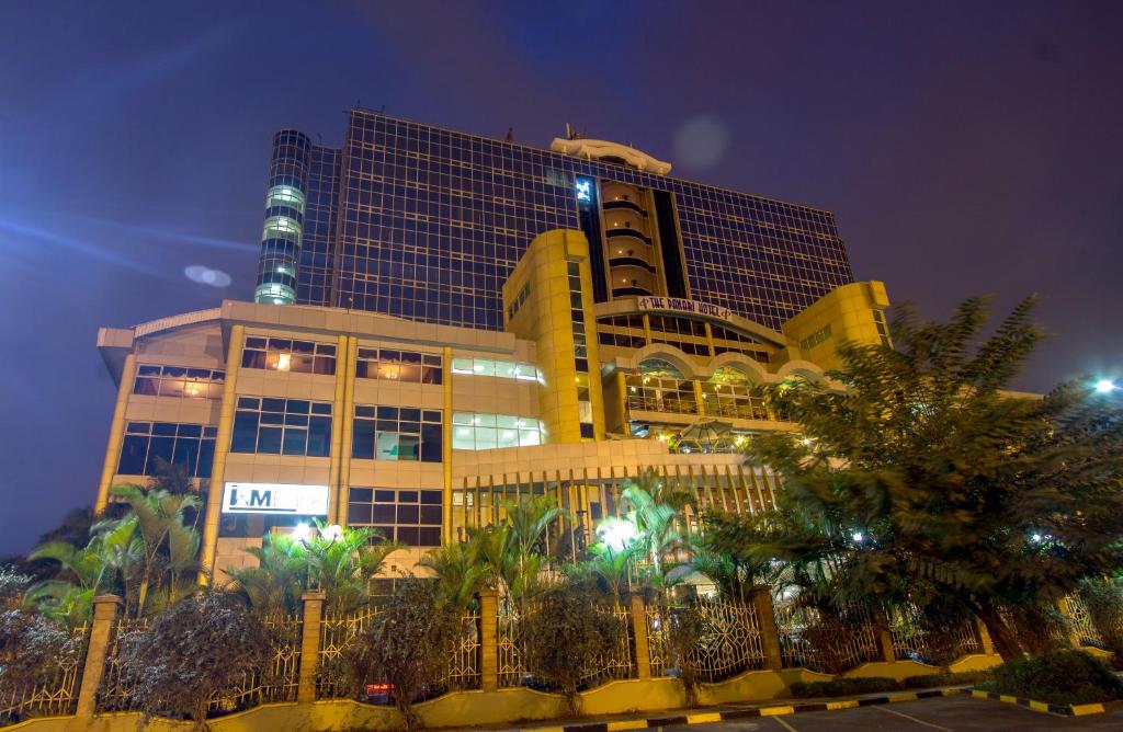um edifício alto com uma cerca em frente em The Panari Hotel - Near Jomo Kenyatta International Airport em Nairobi