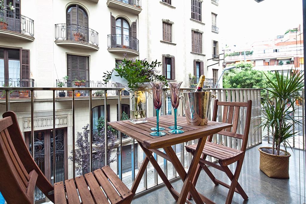 バルセロナにあるApartment Barcelona Rentals - Sarria Apartments Near Centerの木製テーブル、バルコニー(椅子2脚付)