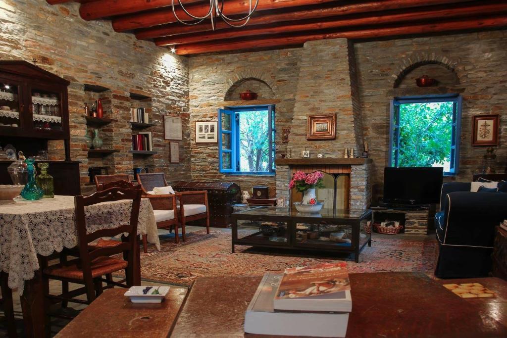 a living room with a fireplace and a stone wall at Saint Louis in Andros