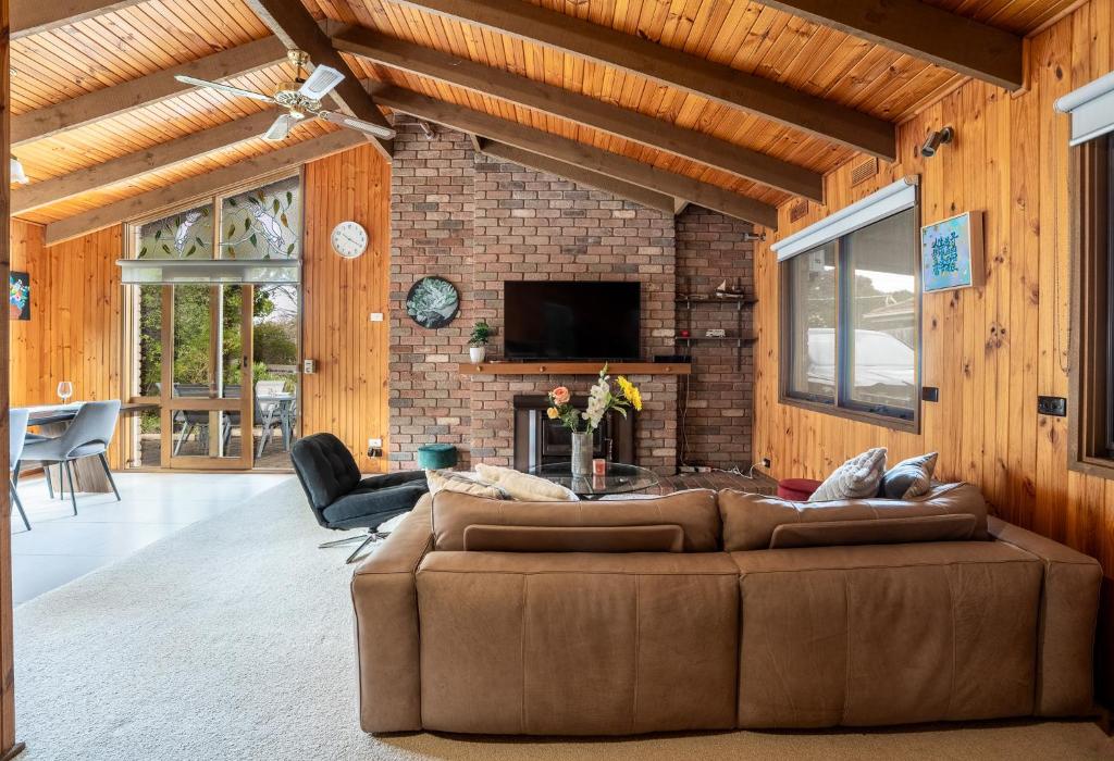 a living room with a brown couch and a fireplace at Spacious, Pet Friendly, Near Boat Ramp and Water in Clifton Springs