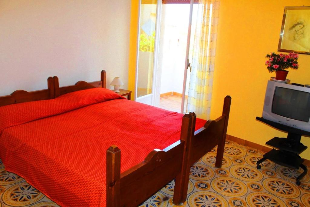トロペアにあるAppartamenti Zarahのベッドルーム(赤いベッド1台、テレビ付)