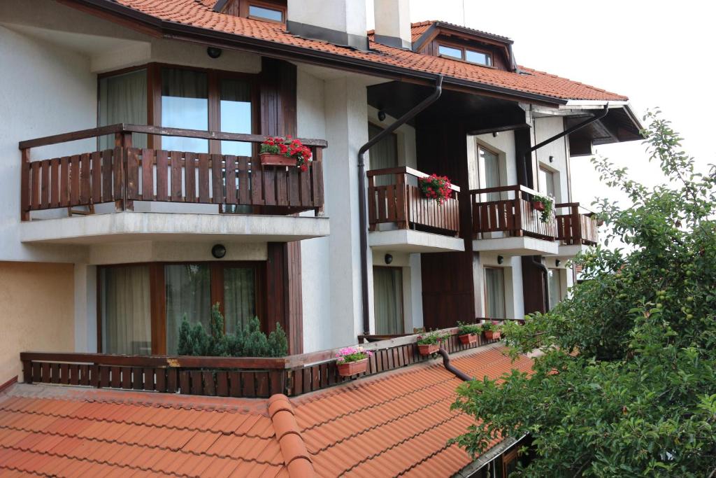 an apartment building with balconies and a red tile roof at Kralev Dvor Hotel in Bansko