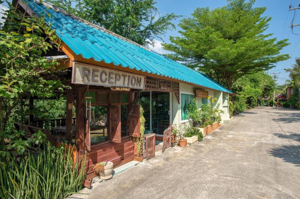 ein Geschäft mit einer blauen Markise auf einer Straße in der Unterkunft Raknatee Resort in Ban Tha Chang (1)