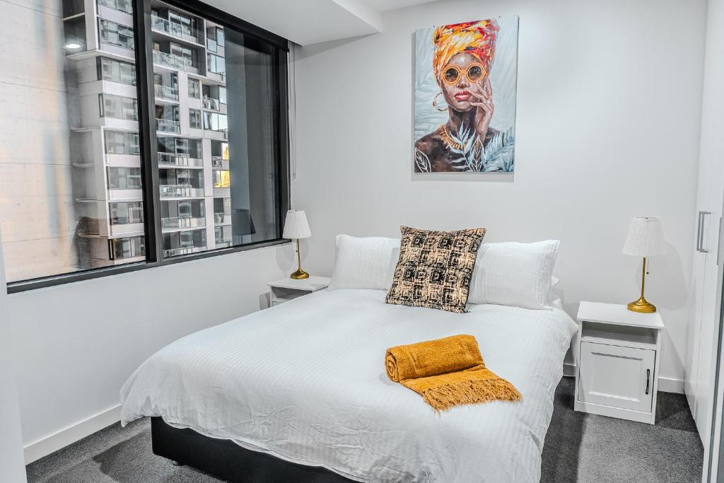 a bedroom with a bed and a painting on the wall at City Living, Prime Location with Parking & Amenities in Melbourne