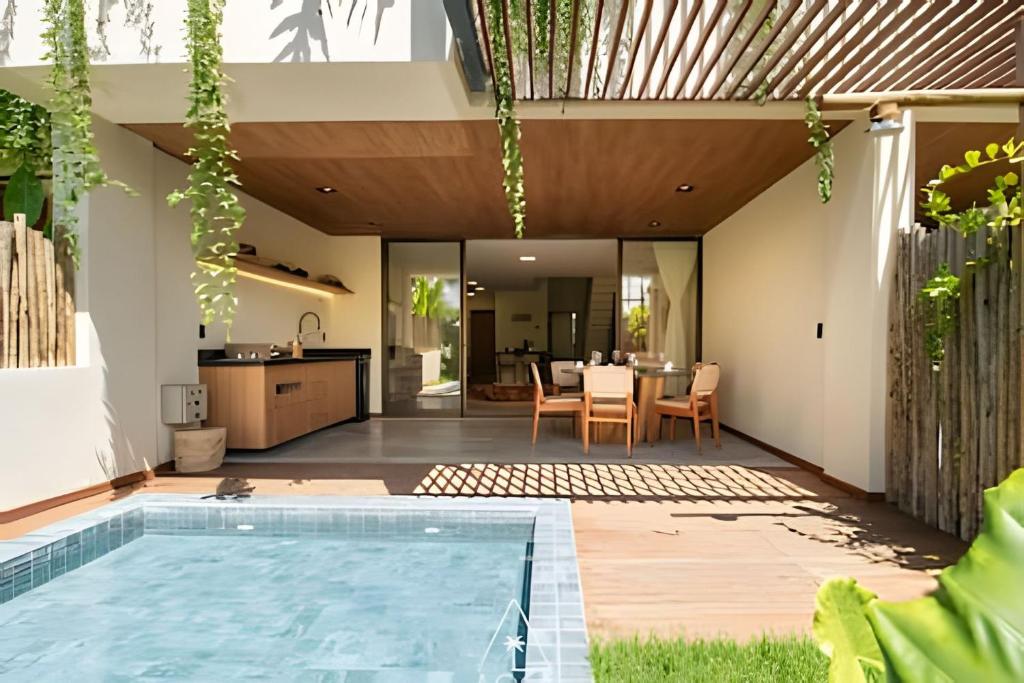 ein Wohnbereich im Freien mit einem Swimmingpool und einer Küche und einem Haus in der Unterkunft Casa Karoá, a Beira-Mar na Rota dos Milagres, Praia de Marceneiro in Barra do Camaragibe