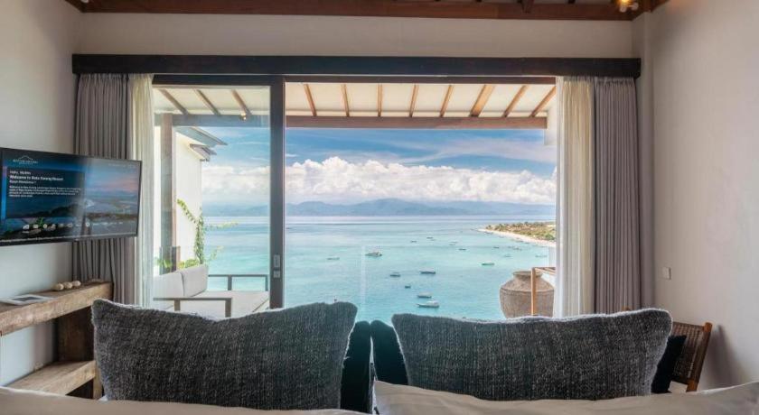 a room with a large window with a view of the ocean at Batu Karang Lembongan Resort & Spa in Nusa Lembongan