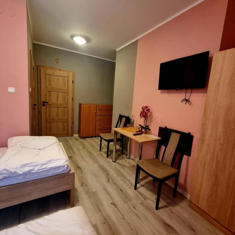 a bedroom with a bed and a table with chairs at Dom Brama Mazur in Ostróda
