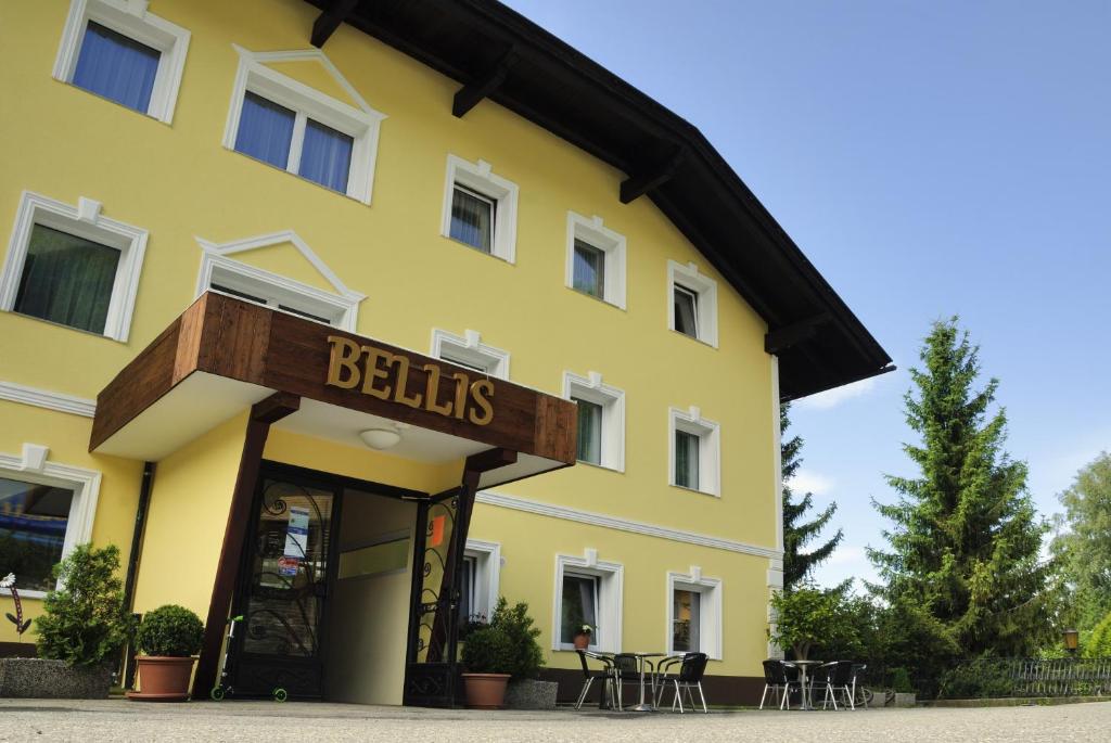 un edificio amarillo con un letrero que lee campanas en Bellis Hotel, en Sankt Urban