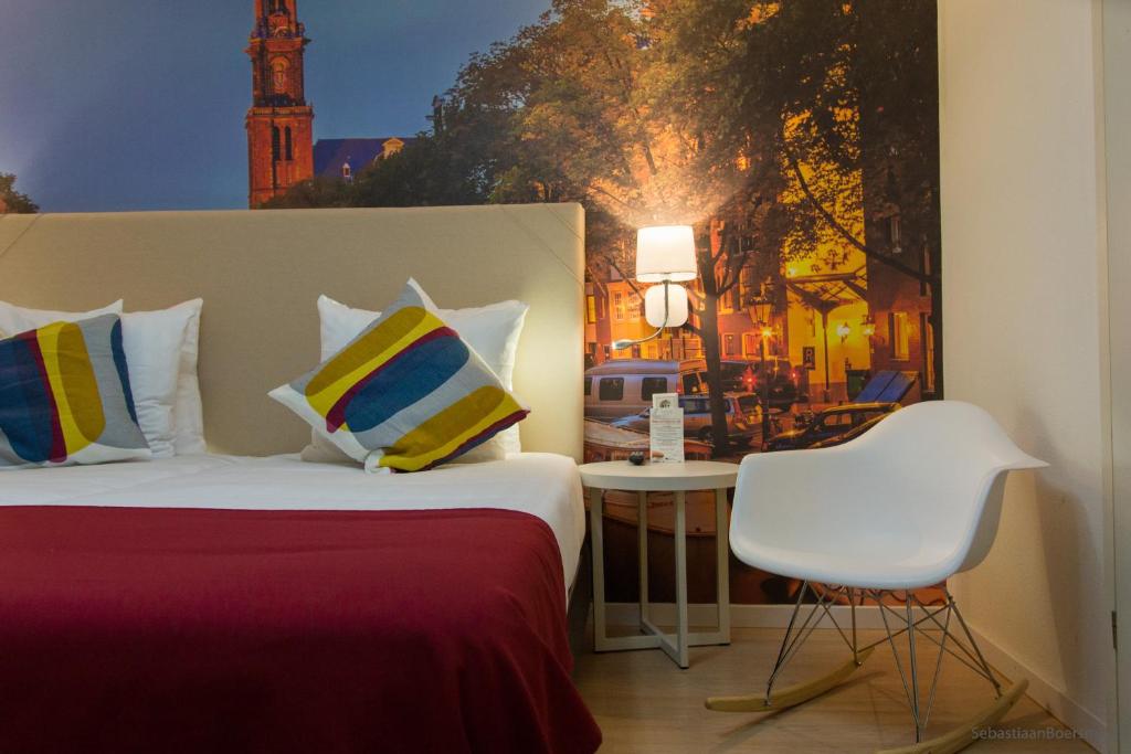 a bedroom with a bed and a chair and a clock tower at France Hotel in Amsterdam