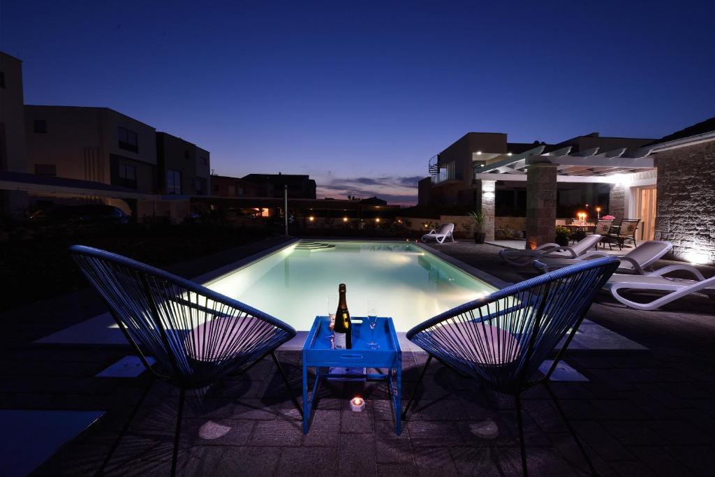 a woman sitting on a table in front of a swimming pool at Villa Stina in Sukošan