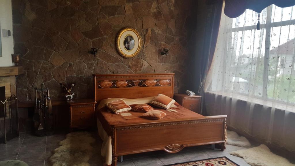 a bedroom with a wooden bed in a room with a window at Гостиница "Сапсан" in Pavlodar