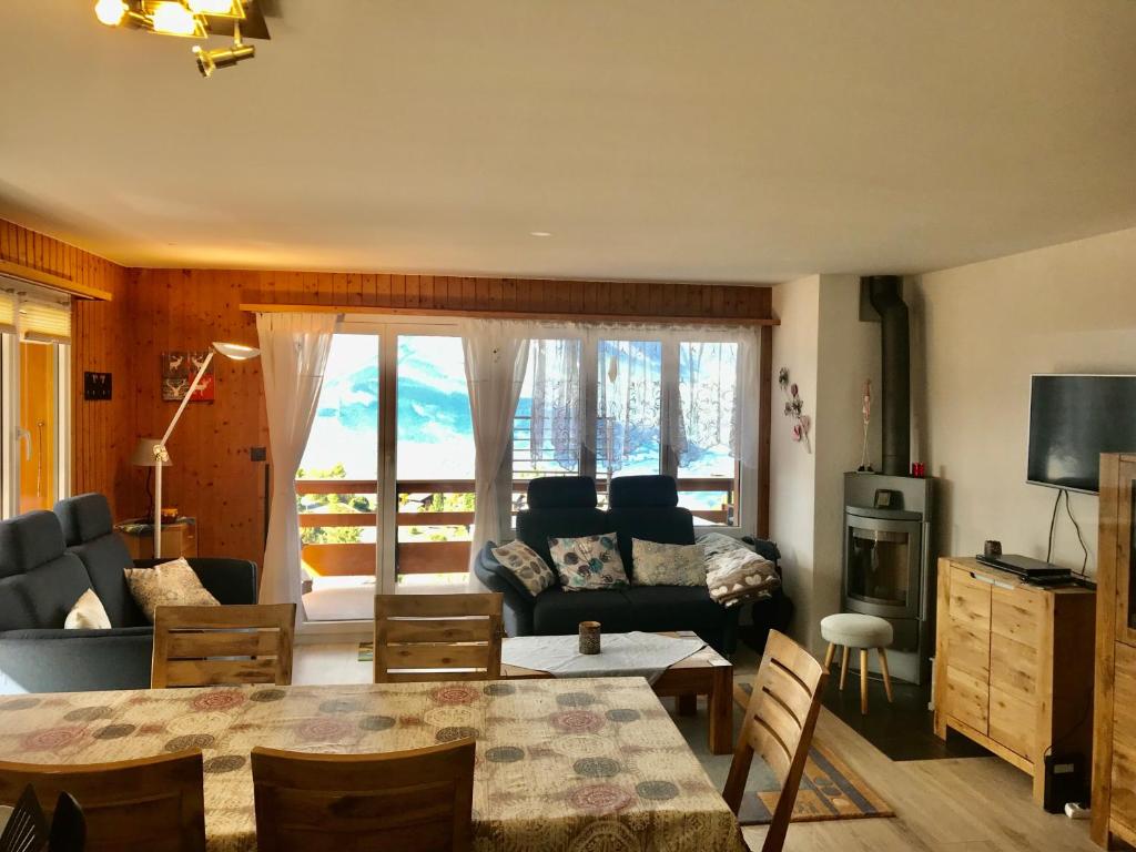 un soggiorno con un divano e un tavolo di Derborence centre 3 pièces 75 m2 piscine balcons a Nendaz