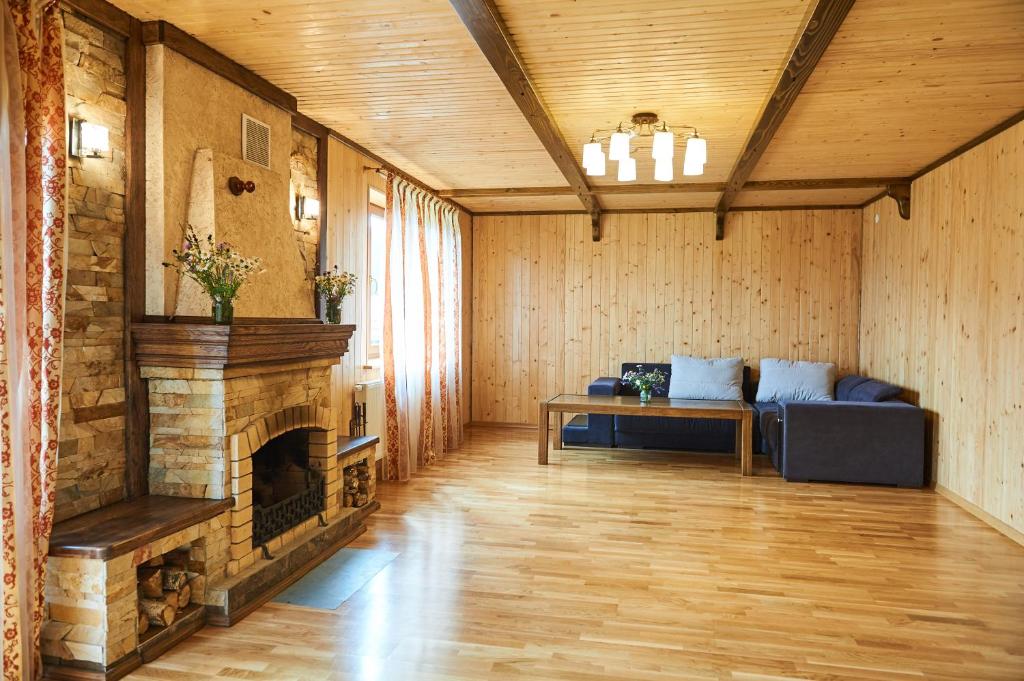 a living room with a fireplace and a couch at Panskyi Kut in Bukovel