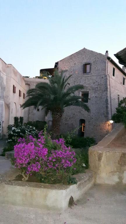 eine Palme und Blumen vor einem Gebäude in der Unterkunft Apartment in a 16th Century Fortress in Tuscany in Porto Ercole