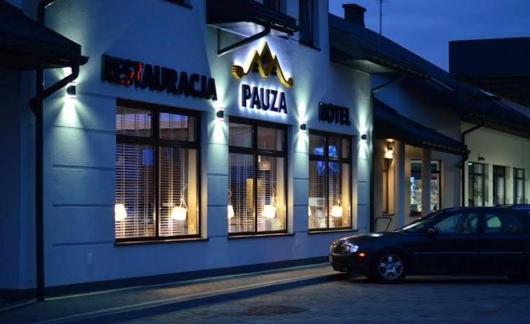 a car parked in front of a pizza restaurant at night at Hotel Pauza in Radzyń Podlaski
