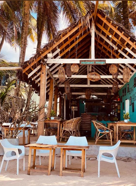 a restaurant with tables and chairs and palm trees at Sunset Haven in Habaraduwa Central