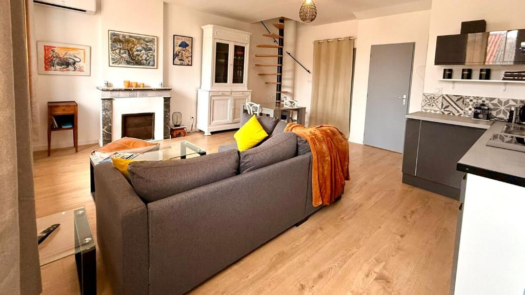 un soggiorno con divano grigio e camino di TIKAZ Béziers - Appartement - 2 Chambres Hyper Centre a Béziers