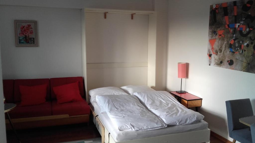 克拉科夫的住宿－Climate of the 60's，一间卧室配有一张床和一张红色的沙发