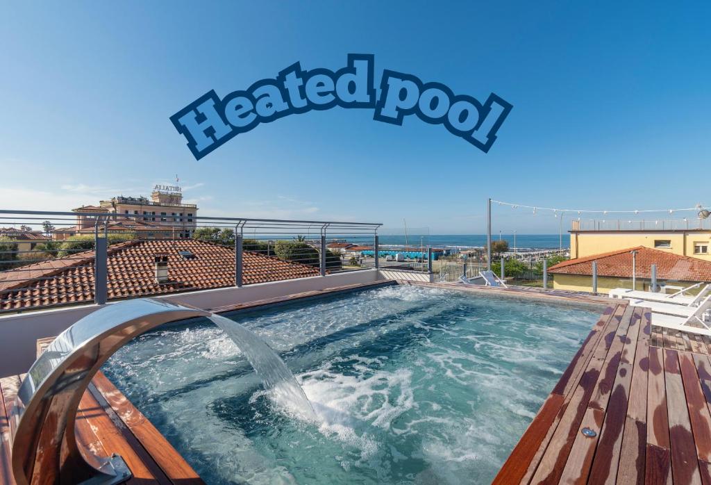 a heated pool with a water slide on top of a building at Residence Stella in Marina di Massa