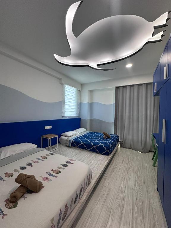 ein Schlafzimmer mit zwei Betten und einem falschen Wal an der Decke in der Unterkunft reStary room 2 in Kota Kinabalu