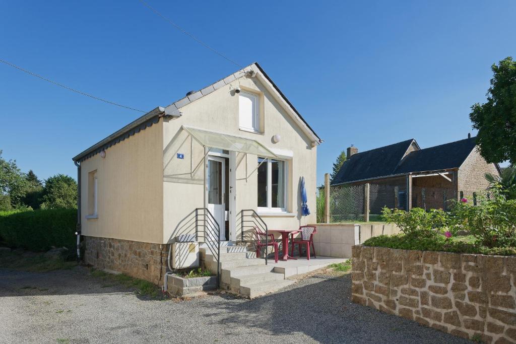 a small white house with a table and chairs at La petite maison in Monthault