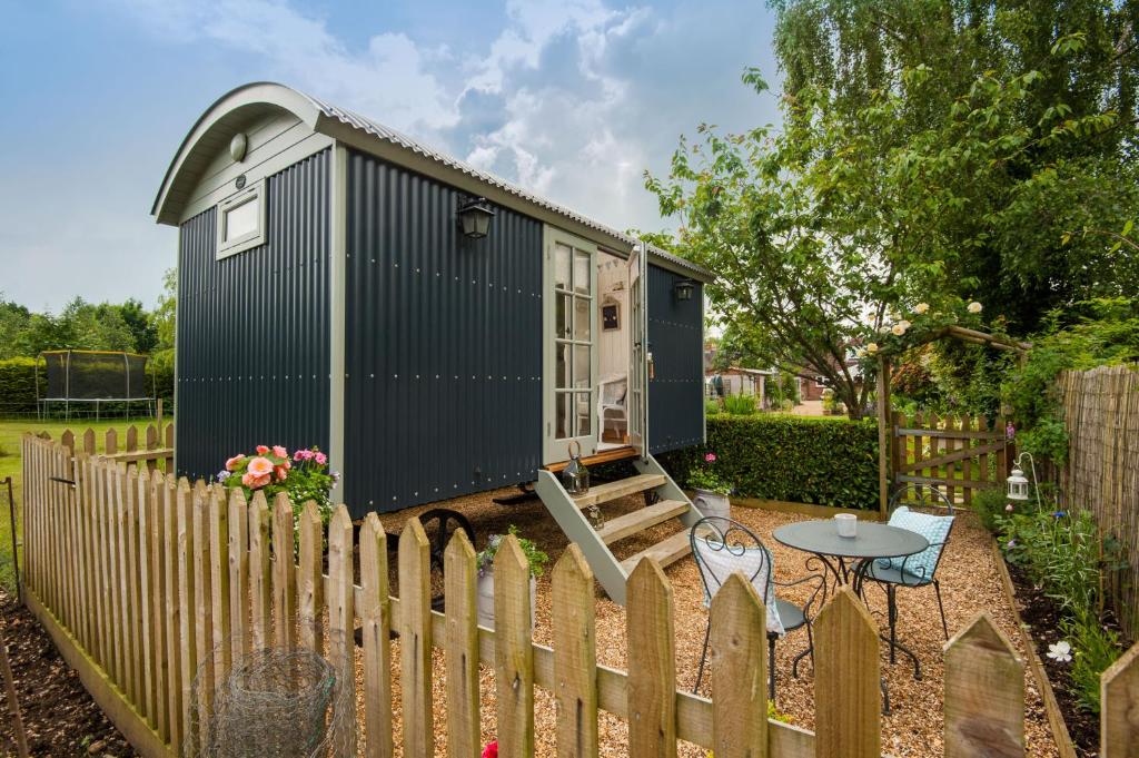 a black tiny house behind a fence at Dolly at Lowlands in Ringwood