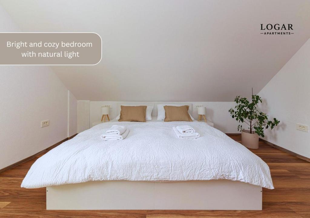 a bedroom with a white bed with two towels on it at LOGAR Apartments in Preddvor