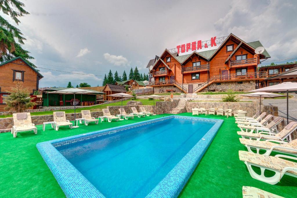 a pool at a hotel with chairs and a resort at Torba in Bukovel