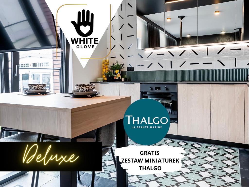 a kitchen with a table and a counter top at Apartamenty WHITE GLOVE Parkya Central Park in Olsztyn