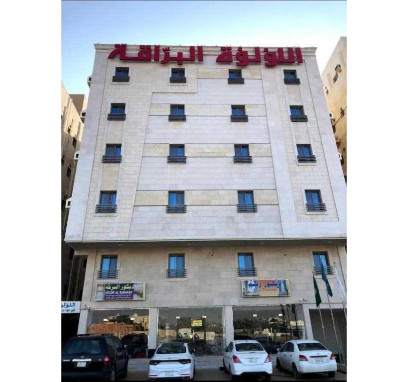 a building with cars parked in front of it at Sunday Pearl Suites Formerly Al Louloah Al Baraqah Apartments in Jeddah