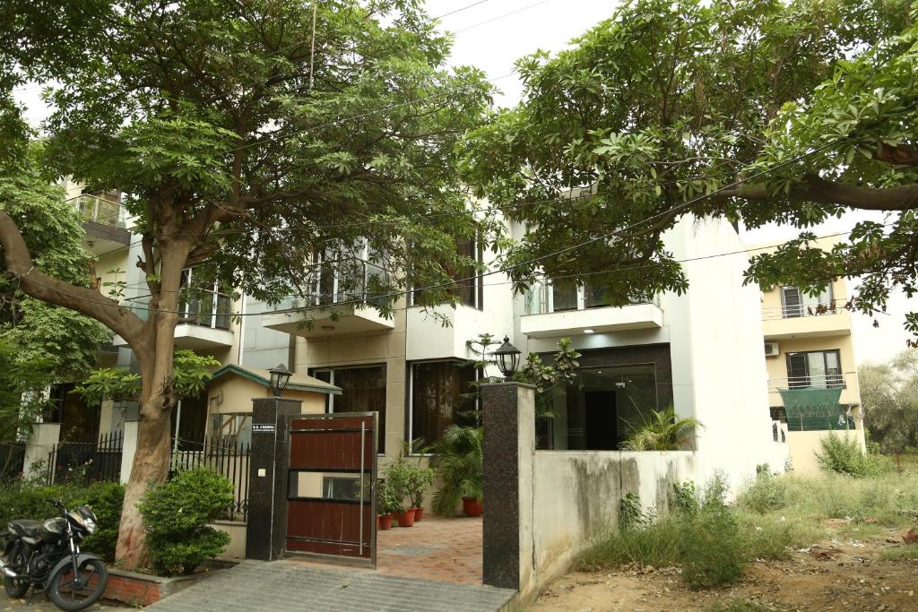 un edificio blanco con un árbol delante en Imperial Apartment Fortis, en Gurgaon