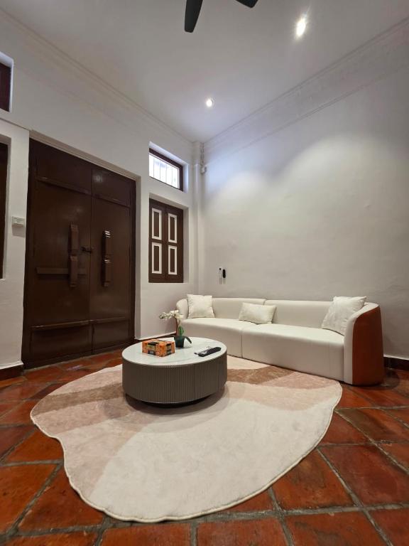 ein Wohnzimmer mit einer weißen Couch und einem Tisch in der Unterkunft Popular! 4 pax Georgetown Heritage Pre-war House 2 Bedroom in George Town